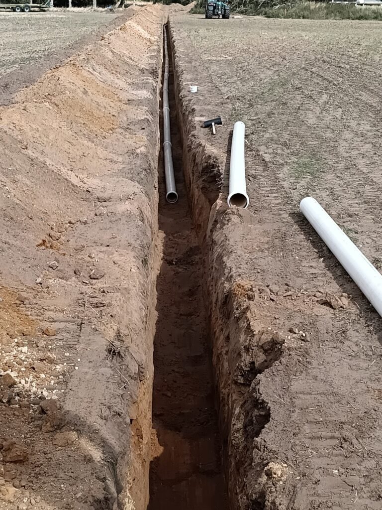 Installing 200 mm (8 inch) underground irrigation main pipework for Wretham Farming Partnership, carried out by AG Rural Solutions with precision trenching and pipe jointing for agricultural water management.